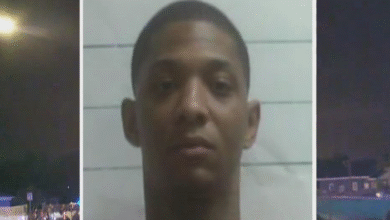 A mugshot of a person with short hair is centered between two nighttime street scenes with lights and buildings.