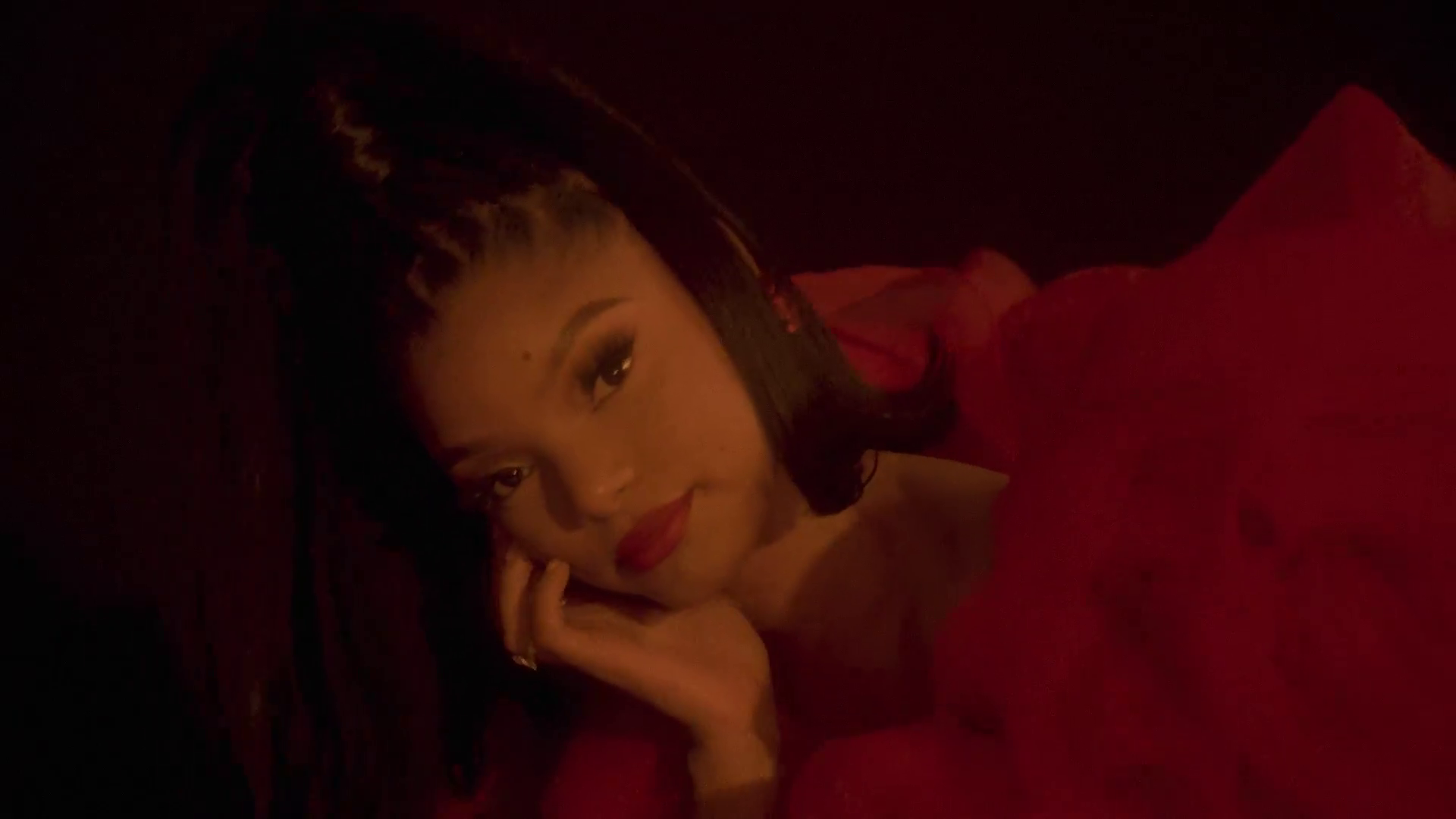 Halle Bailey Announces Debut Album 'Love? Or Something Li... 1 Halle Bailey at an event, wearing a dark halter dress with braided hair. She is smiling against a backdrop with text.